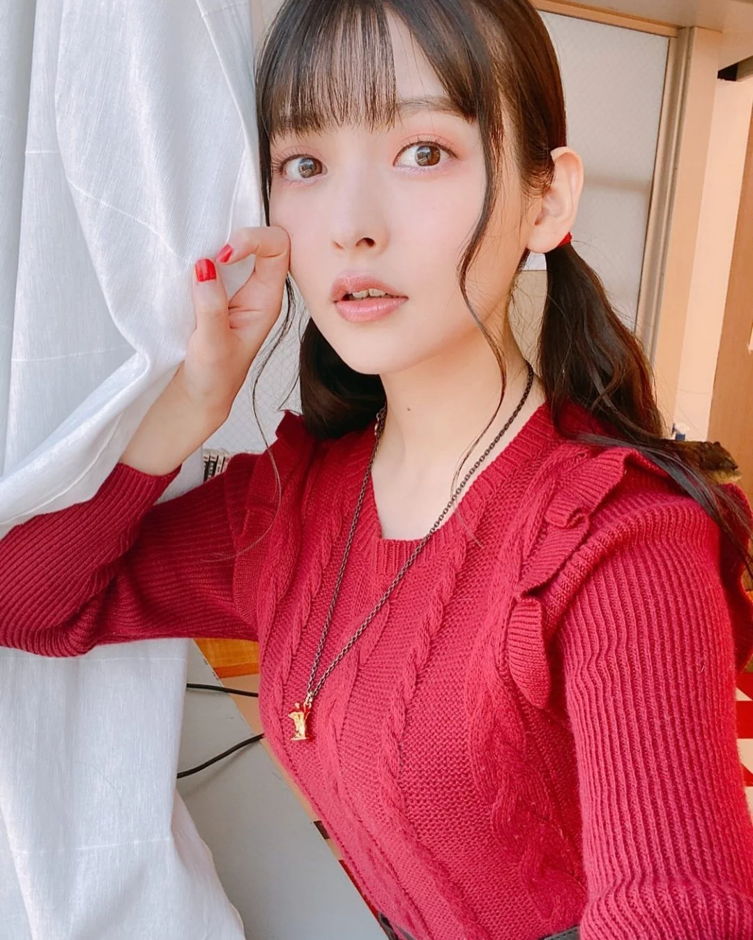 红毛衣女孩摸着脸颊