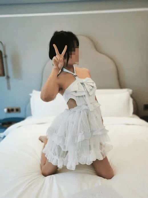 跪床上比耶的白裙妹子