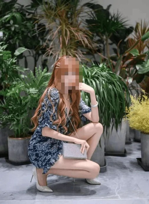绿植前她蹲着拍照